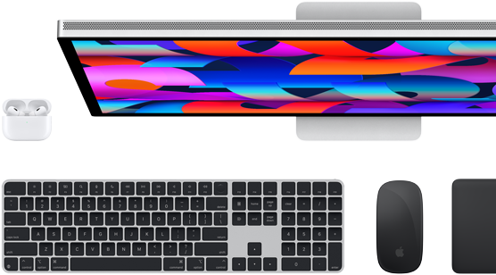 Vista de cima do monitor Studio Display, Magic Keyboard preto, Magic Mouse preto, Magic Trackpad preto e caixa para AirPods branca